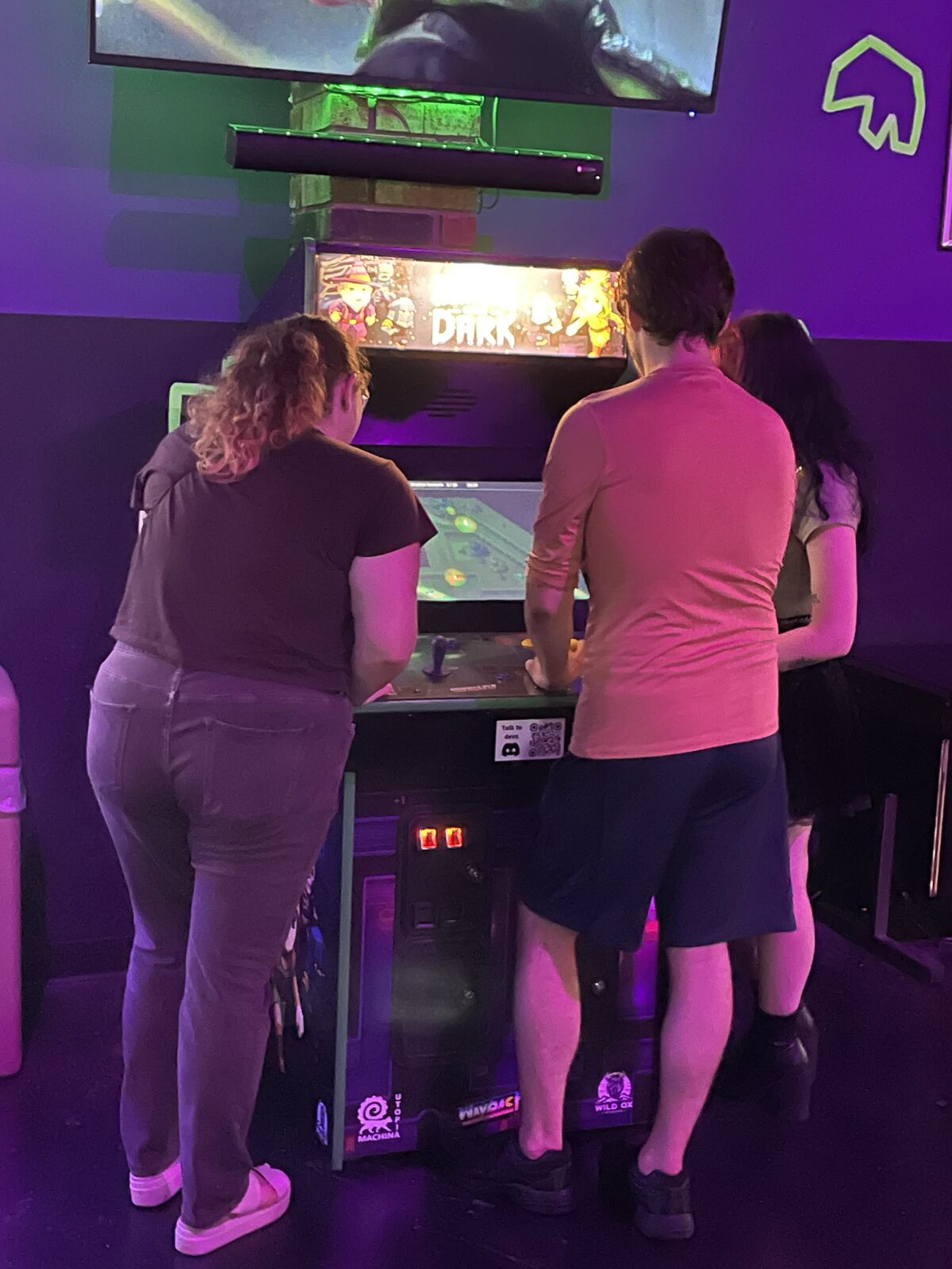 Three players using the custom Hunters In The Dark arcade cabinet